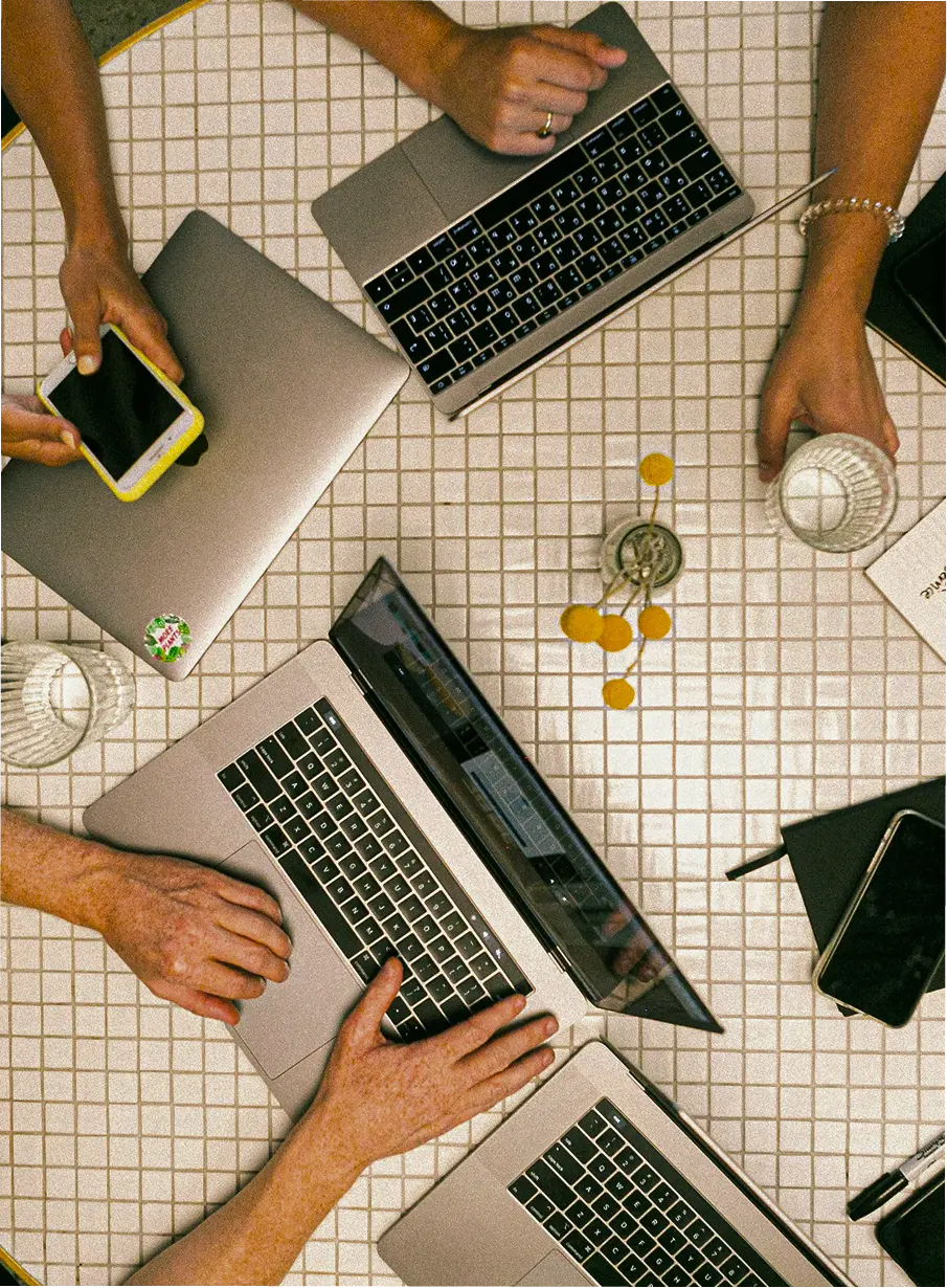 A group of people having a meeting with their laptops and phones out